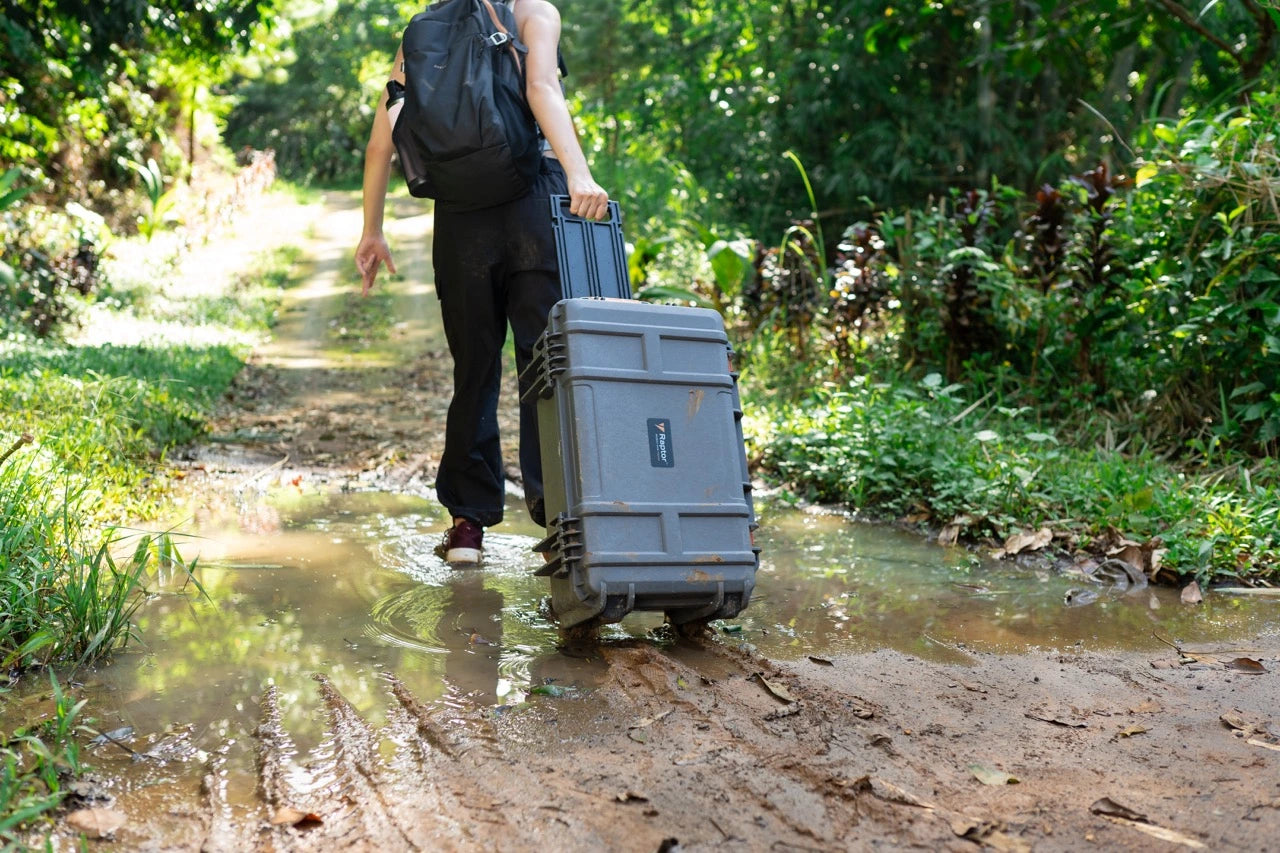 Person walking through a forest with a Raptor Air Case Trolley